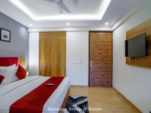 古尔冈Saltstayz Hotel Huda City Centre的卧室配有一张床铺,墙上配有电视