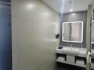 潍坊尚客优品潍坊奎文区世纪泰华人民医院酒店的一间带水槽和镜子的浴室