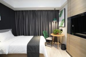 泰州尚客优品泰州姜堰区亚美国际酒店的酒店客房设有床、桌子和电视。