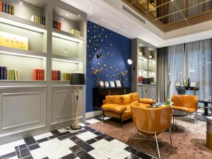 万州重庆万州区观音岩鸿鸥广场兰欧酒店的一个带橙色椅子和蓝色墙壁的沙龙
