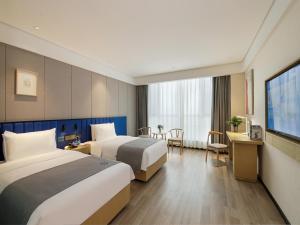 Kuqa库车市太古里夜市兰欧尚品酒店的酒店客房设有两张床和电视。