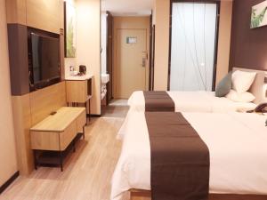 日喀则尚客优品日喀则扎什伦布寺酒店的酒店客房设有两张床和电视。