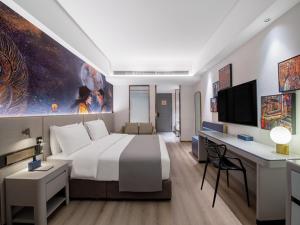 拉萨拉萨市政府西藏大学兰欧国际酒店的酒店客房设有一张大床和一张书桌。