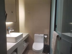 拉萨尚客优品西藏拉萨当热东路酒店的浴室配有白色卫生间和盥洗盆。