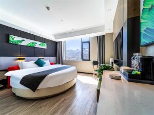 拉萨尚客优品西藏拉萨当热东路酒店的一间带大床的卧室和一间客厅