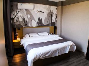 明光尚客优精选滁州明光星光商贸城酒店的卧室配有一张白色大床,墙上挂有绘画作品