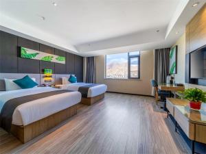 拉萨尚客优品西藏拉萨当热东路酒店的酒店客房配有两张床和一张书桌