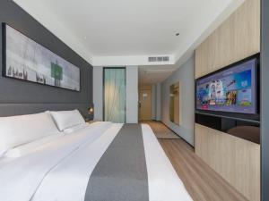 临沂市尚客优悦临沂嘉兴水果市场酒店的一间卧室配有一张大床和一台平面电视