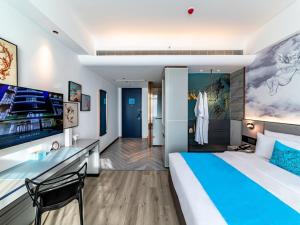 福州福州长乐区长乐机场漳港兰欧酒店的酒店客房设有一张大床和一张书桌。
