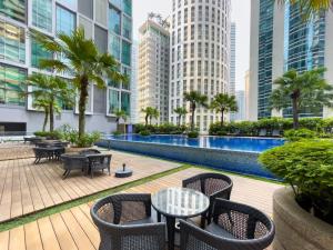 吉隆坡Soho Suites KLCC by Wakely Kuala Lumpur的一个带桌椅的户外庭院,并拥有一座建筑