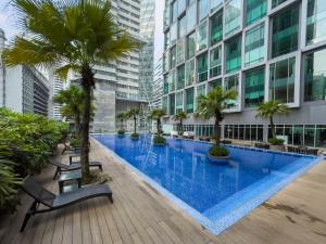 吉隆坡Soho Suites KLCC by Wakely Kuala Lumpur的一座棕榈树和建筑的大型游泳池