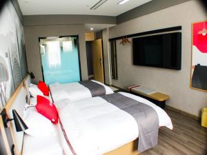 明光尚客优精选滁州明光星光商贸城酒店的酒店客房设有两张床和一台平面电视。