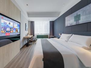 临沂市尚客优悦临沂嘉兴水果市场酒店的一间酒店客房,配有一张大床和一台平面电视