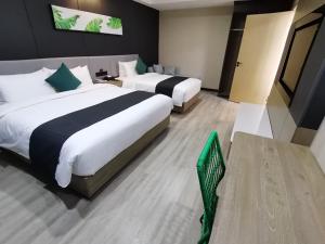 Kuqa尚客优品阿克苏库车幸福路酒店的酒店客房,设有两张床和一把绿色椅子