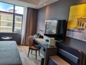 日喀则日喀则龙江路兰欧酒店的一间卧室配有一张桌子、一台电脑和一张床