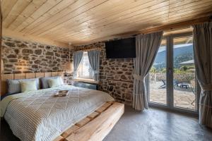 Áyios NikólaosDandy Villas Karpenisi - Lux Chalet的卧室配有一张床,墙上配有电视。