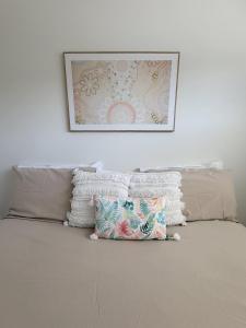 麦夸里港Lazy Stays的挂在床上的图片,上面有枕头