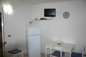 维耶斯泰Case Vacanze Fusillo Rosina的白色的客房设有一张桌子和一台墙上的电视