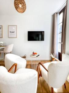 格勒诺布尔Hyper-centre de Grenoble, suite parentale - wifi fibre - cocon的客厅配有白色的椅子、桌子和电视