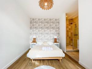 格勒诺布尔Hyper-centre de Grenoble, suite parentale - wifi fibre - cocon的白色卧室配有一张床和一个吊灯