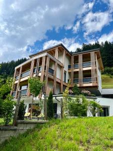 迈尔霍芬Natur Zeit - Alpine Garden Apartments的绿色山顶上的大型房屋