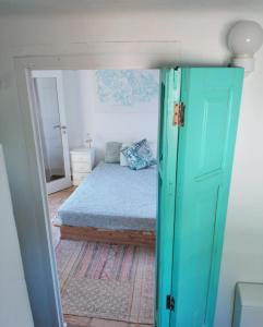 圣布拉什迪阿尔波特尔Casa Papoula的一间卧室配有一张带蓝色门的床