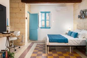 森格莱阿Traditional Maltese Townhouse - Close to Sea的一间卧室配有一张床和一个蓝色的门