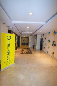 内罗毕Golden Tulip Westlands Nairobi的大楼内带有黄色标志的大走廊