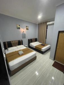 停泊岛Perhentian Suria的酒店客房设有两张床和电视。