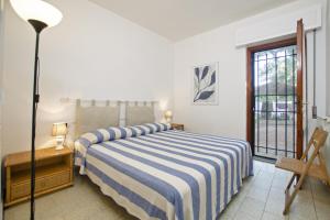 蓬塔阿拉Villetta Il Pino的一间卧室配有一张带蓝白条纹毯子的床