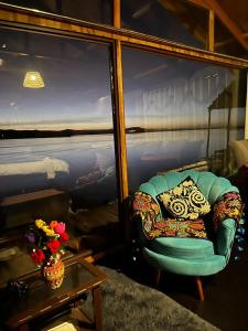 普诺Uros Walysuma Titicaca Lodge的客厅配有椅子和桌子