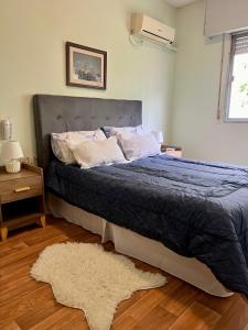 蒙得维的亚HOTEL MEDITERRANEO的一间卧室配有一张带蓝色被子和地毯的床。