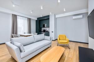 第比利斯Gratus Aparthotel Tbilisi的带沙发和黄色椅子的客厅