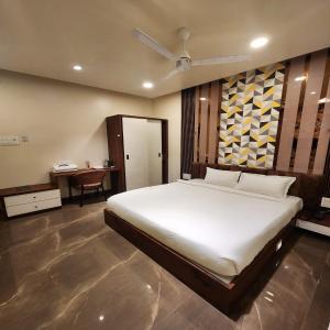 楠代德The Mint Nanded Hotel的卧室配有一张白色大床和一张书桌