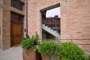 皮耶韦城La Tenenza B&B的砖砌的建筑,窗户上有楼梯