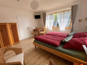 魏尔堡Kleine-Radoase的一间卧室配有一张带红色床单的床和一扇窗户。