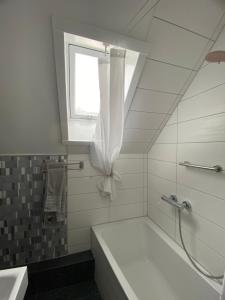 魏尔堡Kleine-Radoase的白色的浴室设有浴缸和窗户。