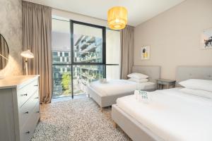 迪拜FAM Living City Walk - Opposite City Walk Mall - 2A的酒店客房设有两张床和大窗户。