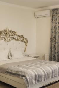 Malyye KhutoraГотель Хутір的一间卧室配有一张白色床和金色床头板
