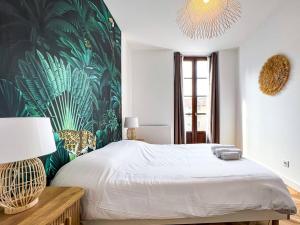 格勒诺布尔Hyper-centre de Grenoble, ambiance tropicale, wifi fibre的一间卧室配有一张带热带壁纸的大床