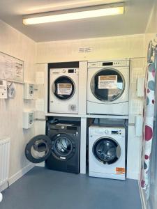 斯代普斯2 Bedroom Self-Catering Chalet的洗衣房配有3台洗衣机和干衣机
