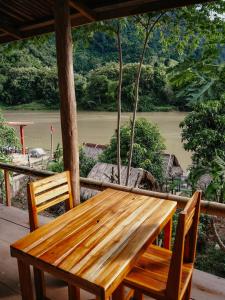 NongkhiawMeexok river view的河景门廊上的木桌和椅子