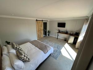 科克斯塔德The Guesthouse Kokstad的卧室配有白色的床和电视。
