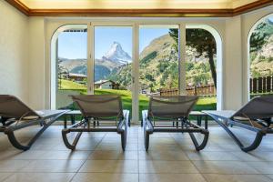 采尔马特阿尔彭皇家酒店的山景客房 - 带椅子和桌子