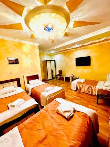 库塔伊西卢克斯宫殿酒店的带三张床和天花板的客房