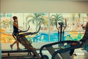 卡达斯诺瓦斯Riviera Park Caldas Novas的一名在健身房跑步机上跑步的女人