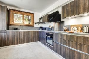 夏蒙尼-勃朗峰Chalet Sol的厨房配有木制橱柜和窗户。