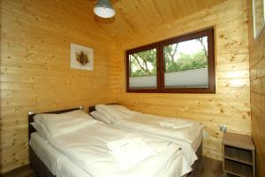 新卡尔奇马Eko-domki w Krynica Morska-Piaski的小木屋内的一张床位,设有窗户