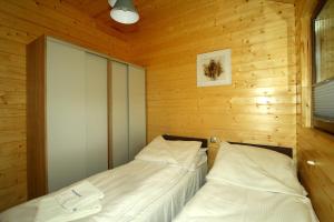 新卡尔奇马Eko-domki w Krynica Morska-Piaski的木墙客房的两张床