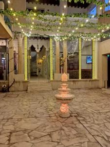 迪拜Hyba Pod Hostel & Hotel的一座灯火通明的建筑中央的喷泉